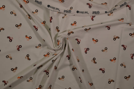 Ecrufarbener Baumwolljersey mit kleinen Traktoren – Detailaufnahme der Stoffstruktur