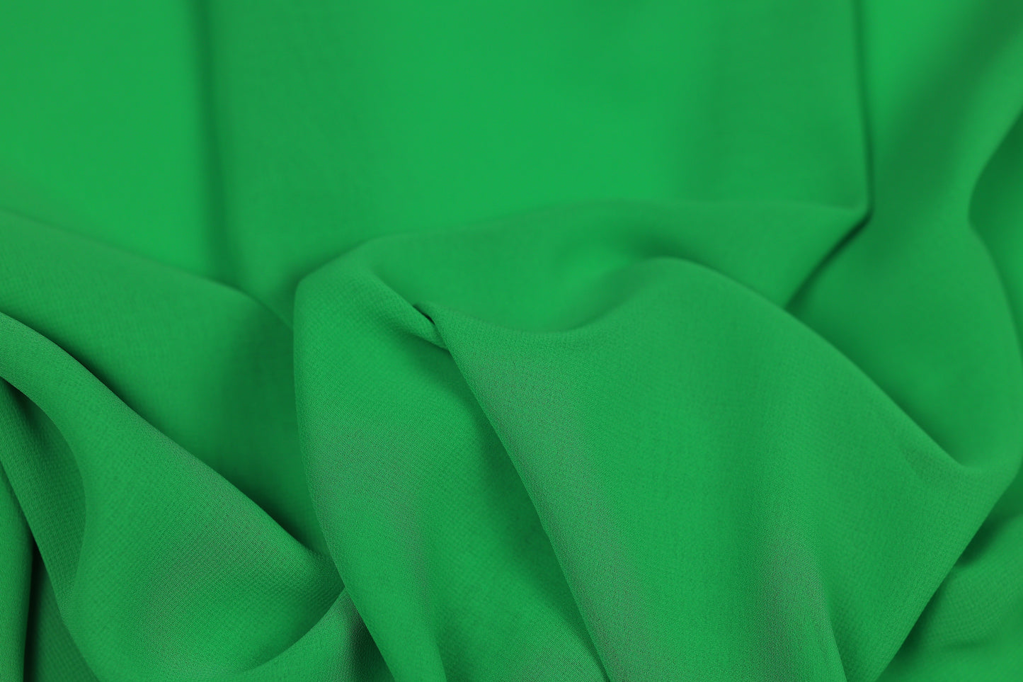 Grüner fließender Chiffonstoff mit elegantem Faltenwurf – ideal für Kleider und Blusen