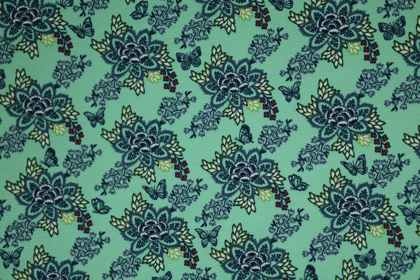 Verspielter Baumwollstoff mit floralen Ornamenten auf Mint.