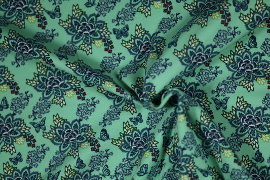 Mintgrüner Stoff mit Blumen und Schmetterlingen – ideal für Kinder.