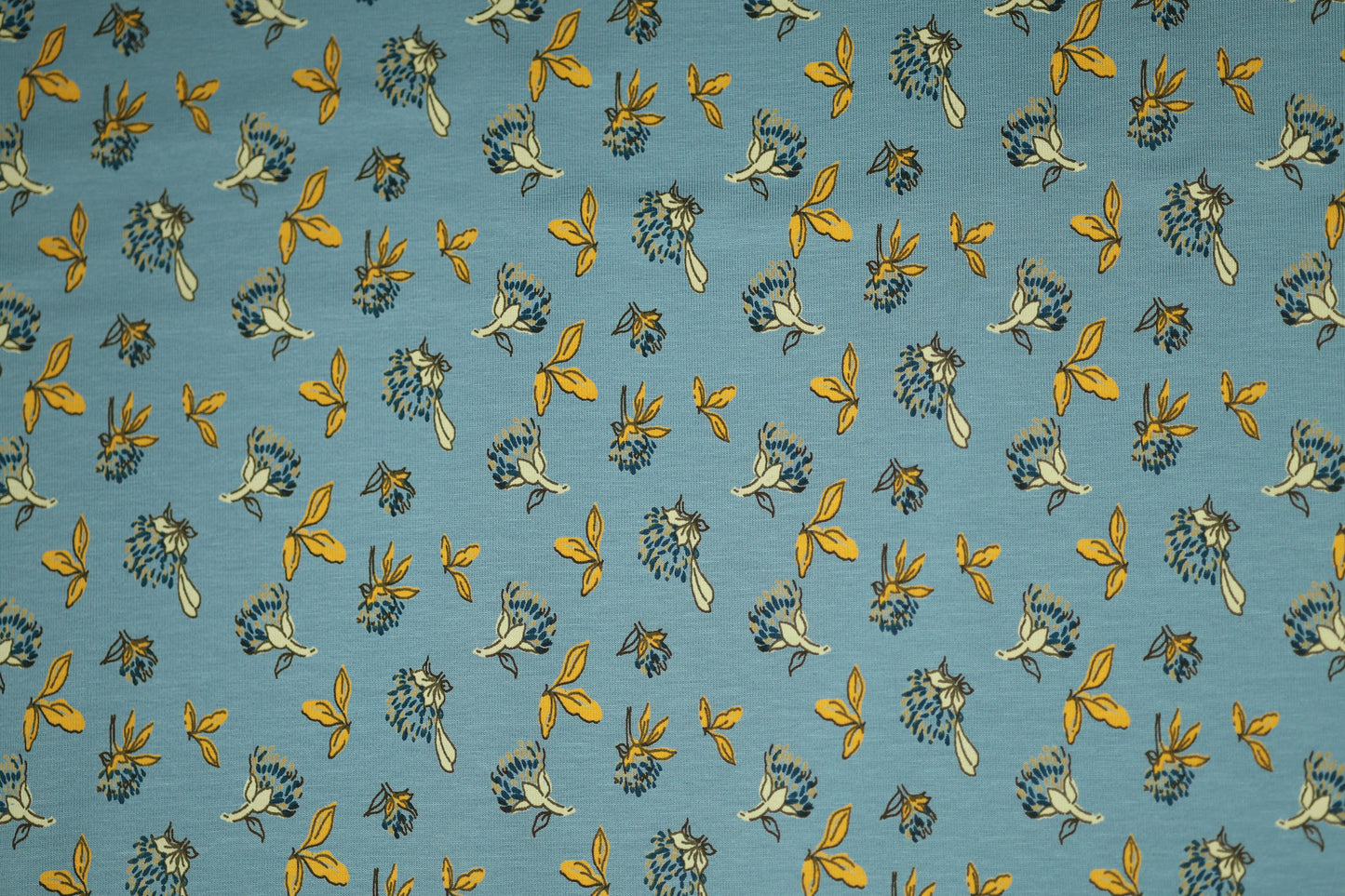 Gelbe Blätter auf Himmelblau – hochwertiger Baumwollstoff für Kinder und kreative Projekte.