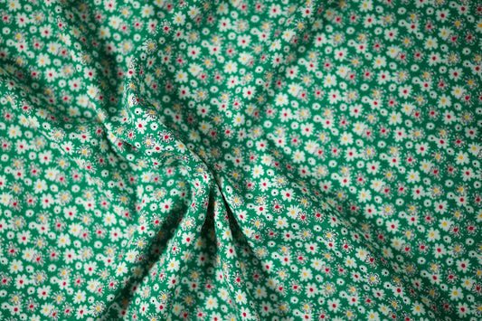 Grüner Viskosestoff mit buntem Margeritenmuster
