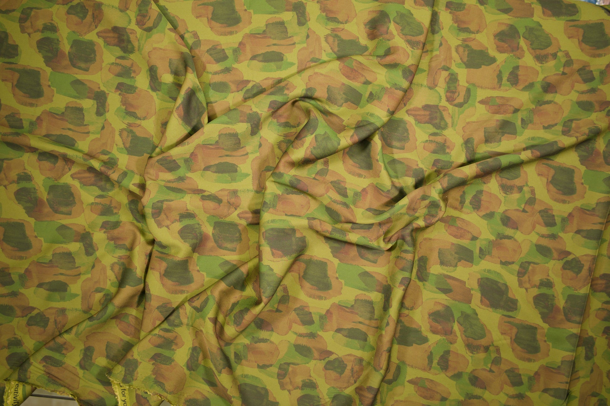 Satin Viskose mit abstraktem Animalprint in Olivgrün und Braun Detailaufnahme der Stoffstruktur