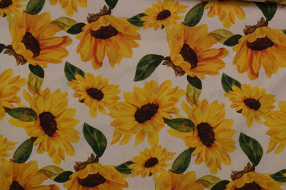 Gelber Sonnenblumenstoff auf hellem Grund – ideal für Kleider, Röcke und Tischdecken