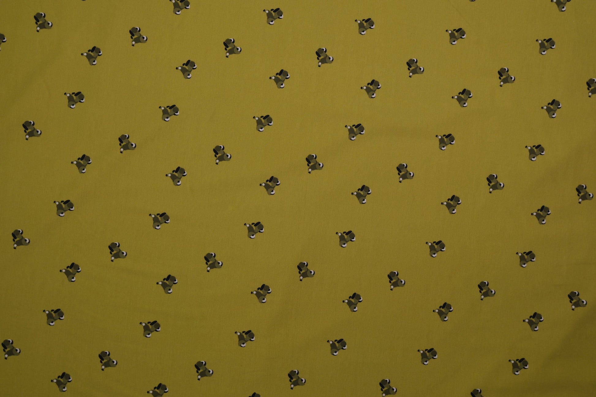 Grüner Baumwolljersey mit kleinen Hundemotiven – Detailaufnahme der Stoffstruktur