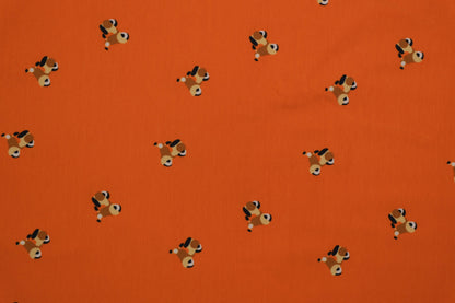 Oranger Baumwolljersey mit kleinen Hundemotiven – 140 cm breit