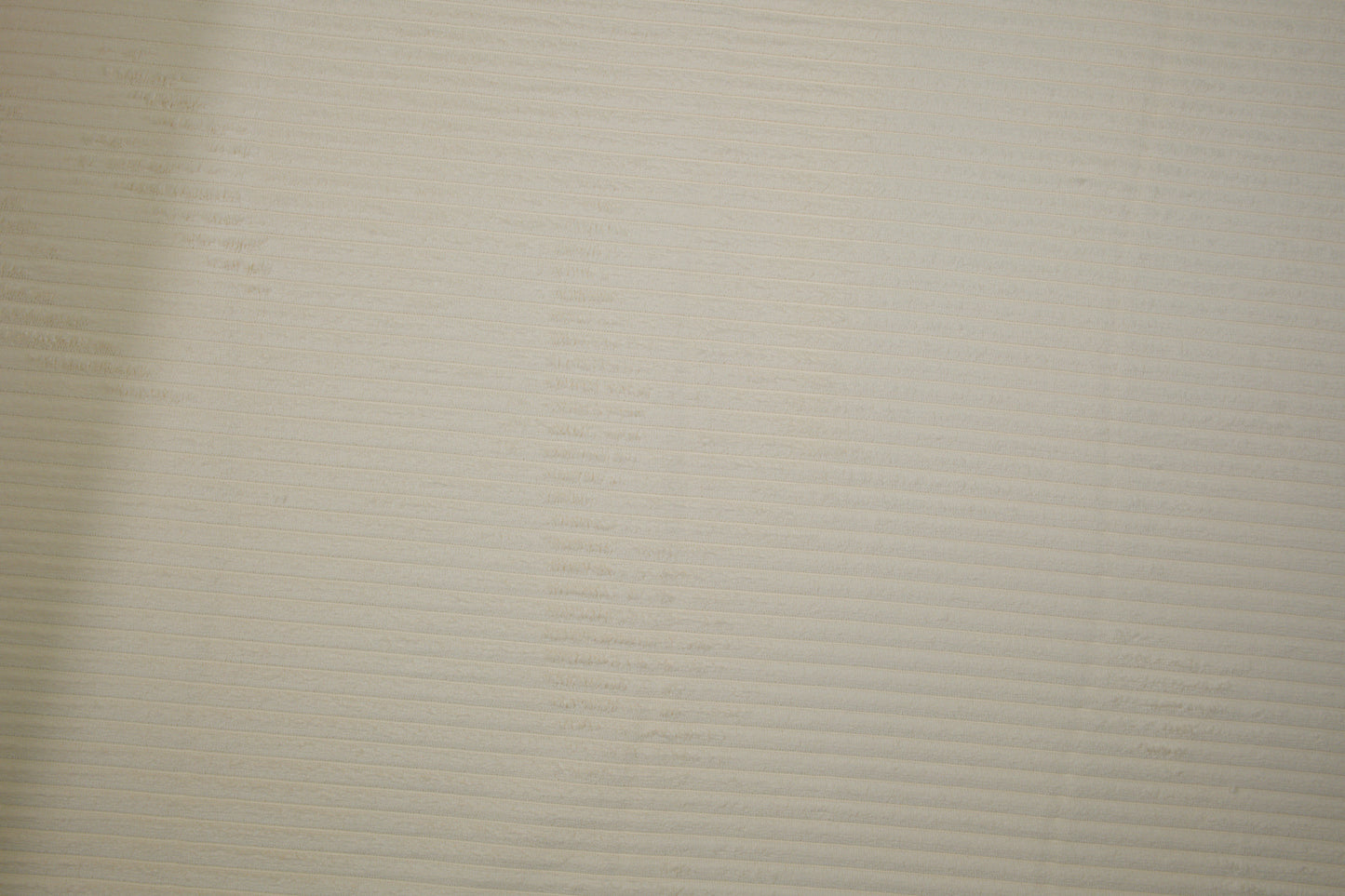 Möbelstoff in Uni-Creme mit glatter, feiner Struktur Detailaufnahme der Stoffstruktur