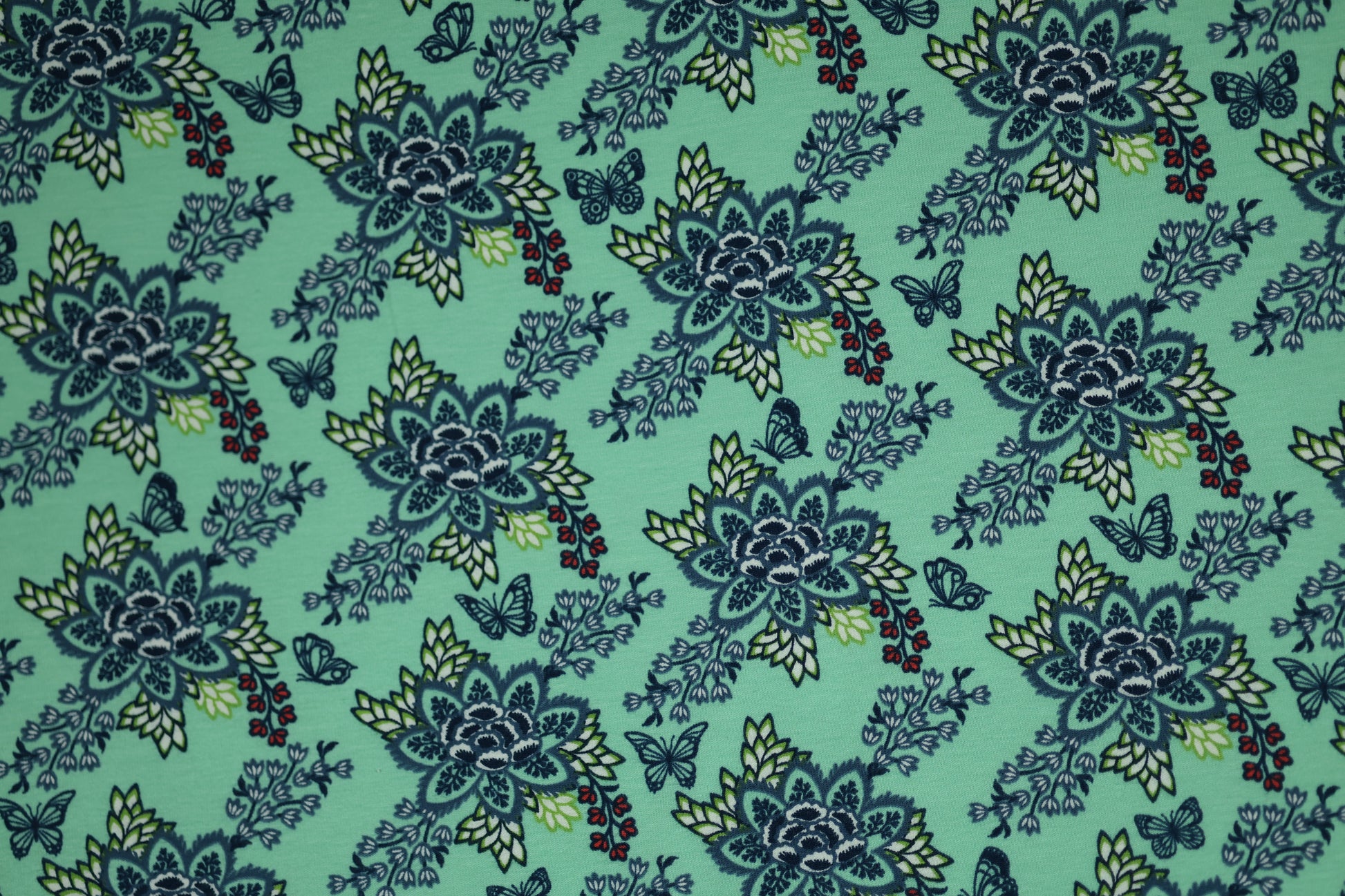 Verspielter Baumwollstoff mit floralen Ornamenten auf Mint.