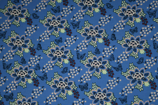 Blauer Baumwollstoff mit floralen Ornamenten und Schmetterlingen.