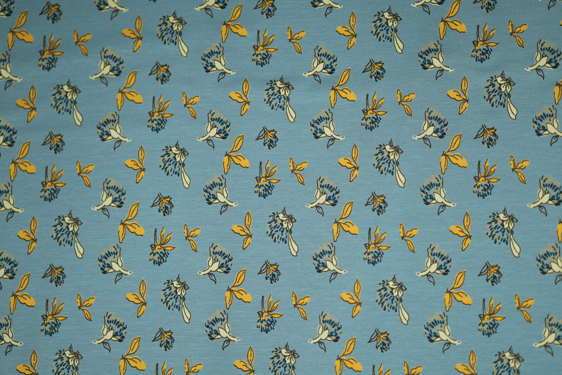 Gelbe Blätter auf Himmelblau – hochwertiger Baumwollstoff für Kinder und kreative Projekte.